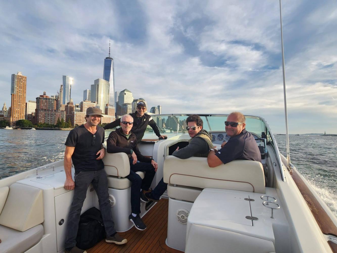 friends on a private boat for a bachelor party with the New York skyline in the background