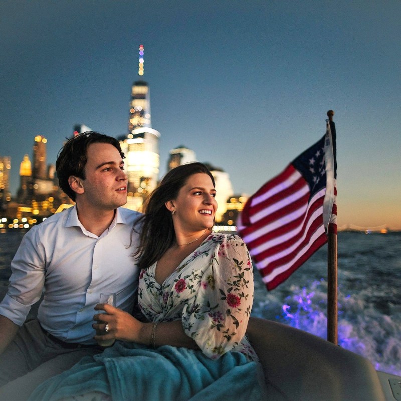 couple on a romantic boat ride with the NYC World Trade Tower and American flag in the background