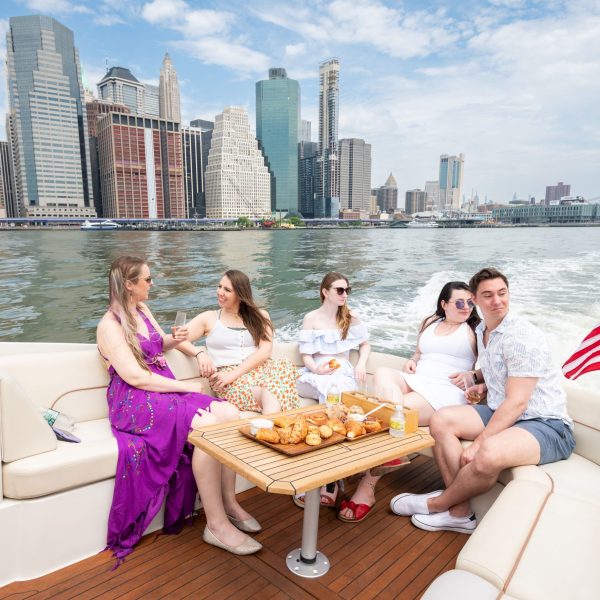 friends on a NY boat rental with the Manhattan skyline in the background