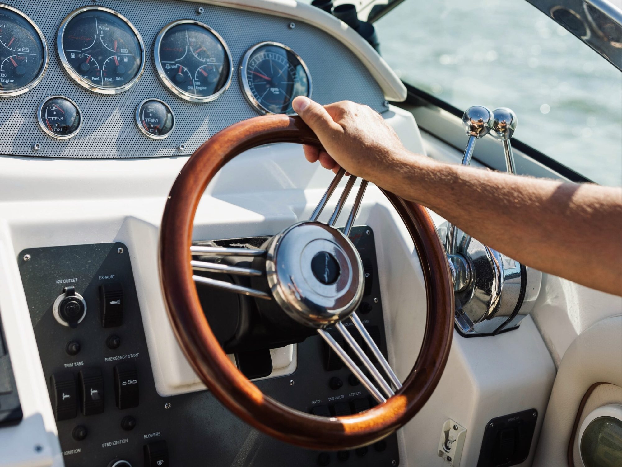 brown steering wheel and captain's arm on a boat rental New York