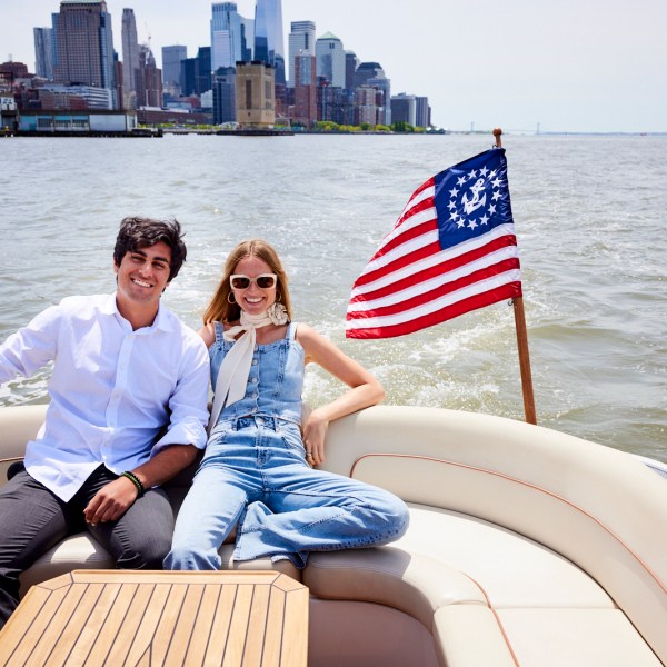 couple on a yacht with the American flag and Manhattan in the background during a private boat ride for 2