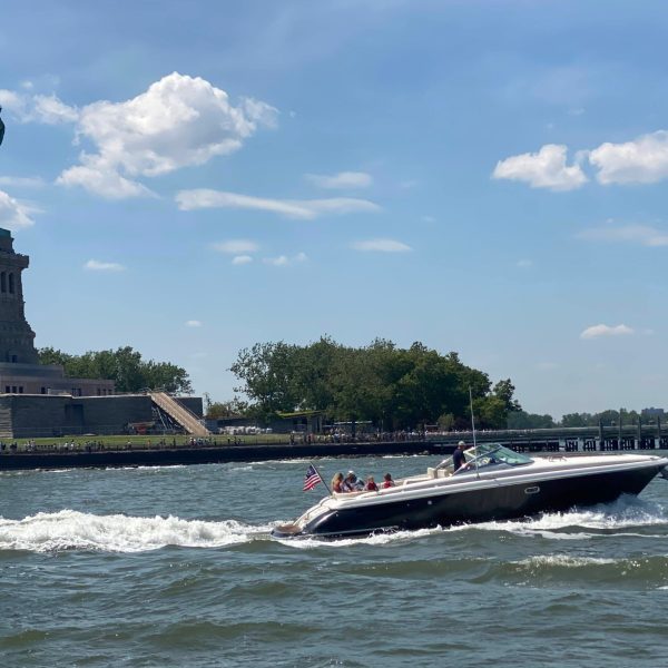private boat in front of the Statue of Liberty giving a tour