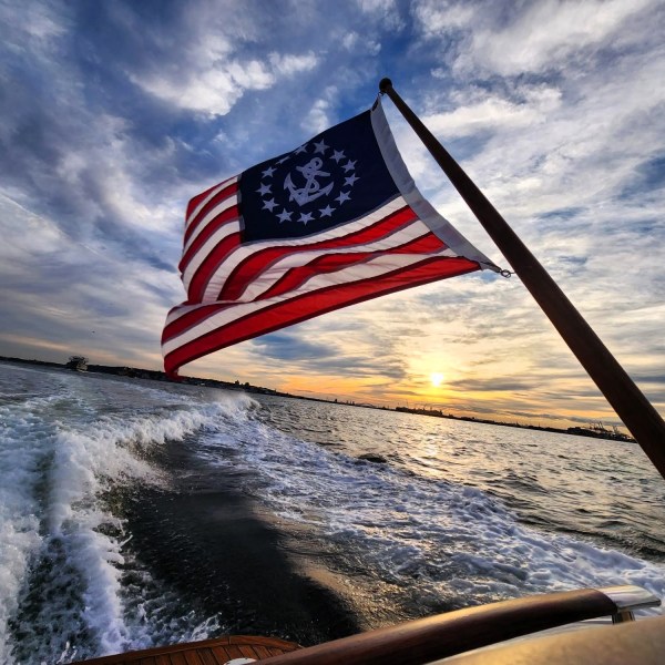 American flag flapping over the water during a sunset cruise in NYC