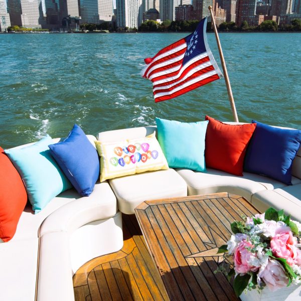 birthday party boat with pillows and flowers and American flag floating in the NY Harbor
