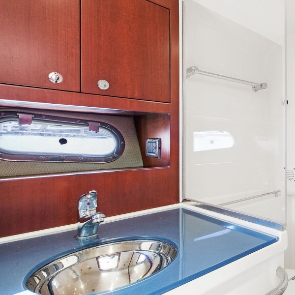 bathroom with a silver sink and blue countertop and mahogany cabinets