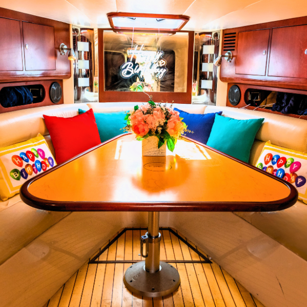decorated rental yacht for a birthday with pillows and sign and flowers