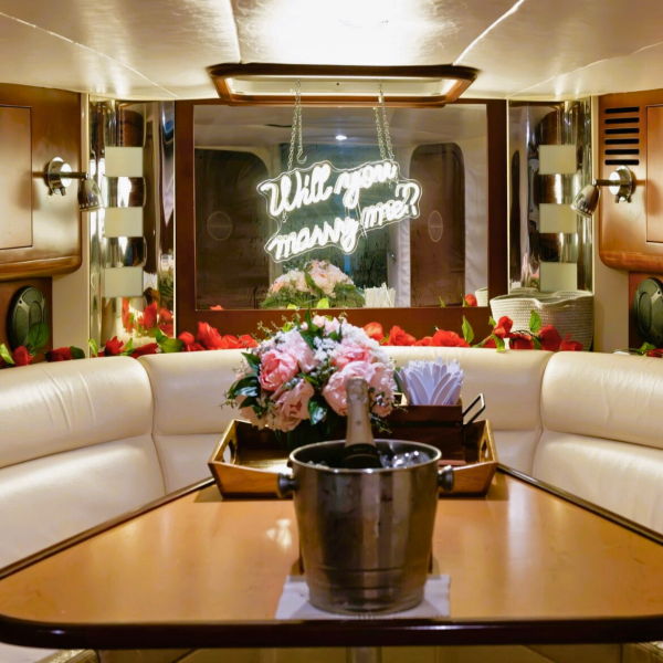 will you marry me sign and flowers and champagne during a proposal on a yacht