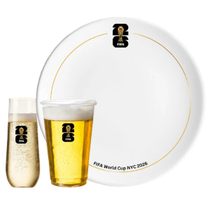 Plate and two glasses with FIFA World Cup NYC 2026 logo, one with champagne, one with beer.