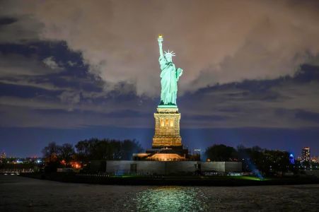 Statue of Liberty illuminated at night during a private night cruise